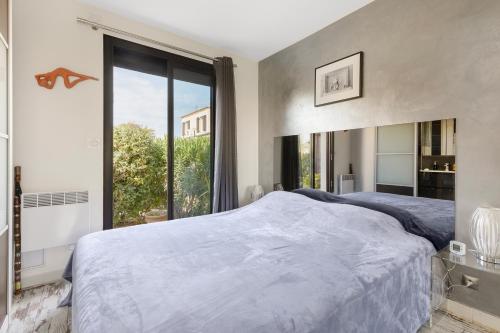une chambre avec un grand lit et une grande fenêtre dans l'établissement Naturistecapdagde Villa Port Venus Serenity, au Cap d'Agde