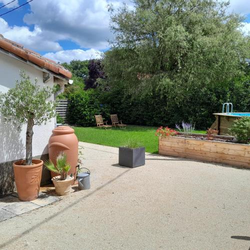 un jardin avec un arbre et une fontaine dans l'établissement La Petite Grange, à Esse