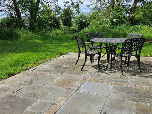 a table and four chairs sitting at a patio at Lilys Cottage Mendlesham Green Stowmarket Suffolk in Stowmarket