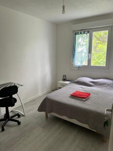 una camera da letto con un letto, una scrivania e una sedia di Appartement T4 a Brest