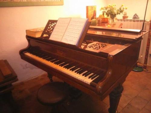 a piano with a book on top of it at Les Asphodeles chambre familiale Lilah in Saint-Hippolyte-du-Fort
