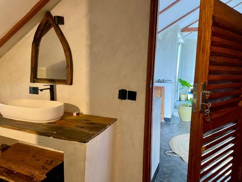 a bathroom with a sink and a mirror on a counter at Baobab Bungalows in Jambiani