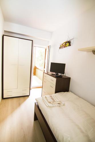 a bedroom with a bed and a desk with a computer at Apartments Club Telgárt in Telgárt