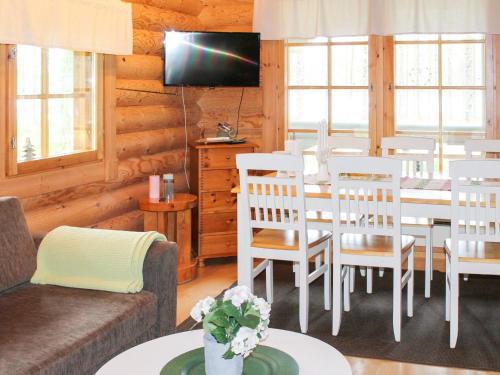 ein Wohnzimmer mit Tisch und Stühlen und einem Fernseher in der Unterkunft Holiday Home Syväniemi by Interhome in Säkkilänvaara