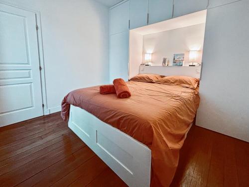 - une chambre dotée d'un grand lit avec des draps orange dans l'établissement Charming Apartment Paris - Rentaway BnB, à Paris