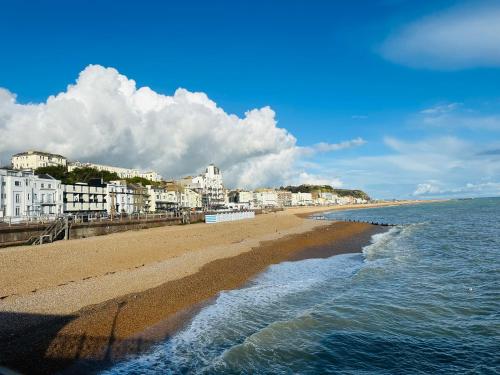 a view of a beach with buildings and the ocean at A modern 2 bedroom seaside apartment in Hastings