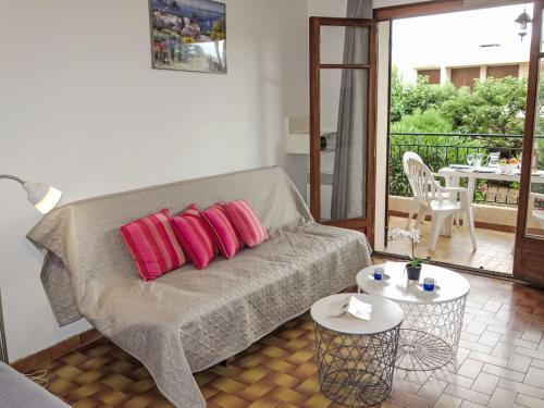 - un salon avec un canapé et deux oreillers rouges dans l'établissement Apartment Provence Village-3 by Interhome, à Saint-Cyr-sur-Mer