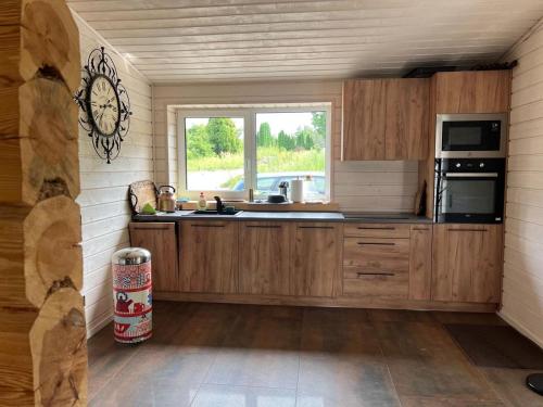 a kitchen with wooden cabinets and a window at Vantos Lapas Rezidencija in Trakai