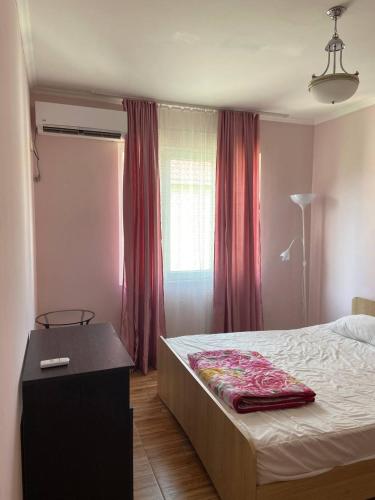 a bedroom with a bed and a table and a window at Guesthouse Mirabela in Shekvetili