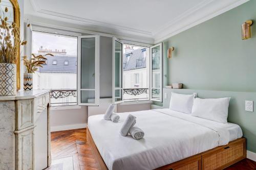 une chambre avec un grand lit et deux fenêtres dans l'établissement SaintGermain Sojourn - Charming 2 bedroom in the Rive Gauche, à Paris