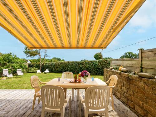 a patio with a table and chairs under a yellow umbrella at Holiday Home Stereden Vor by Interhome in Primelin