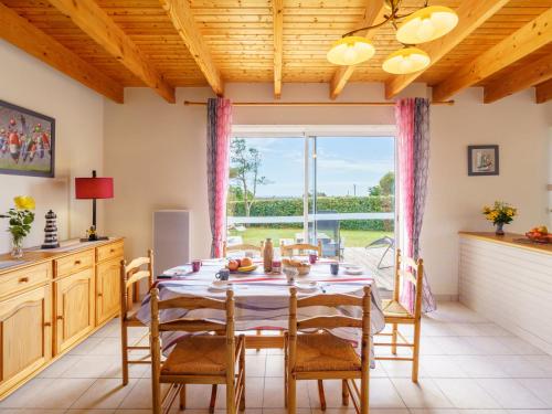 une salle à manger avec une table et des chaises et une grande fenêtre dans l'établissement Holiday Home Stereden Vor by Interhome, à Primelin