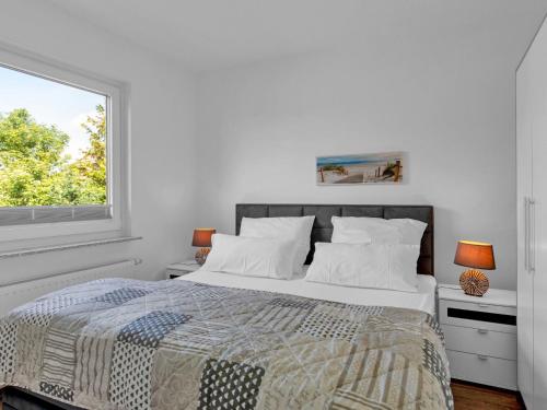 una camera da letto bianca con un letto e una finestra di Apartment Seeschwalbe by Interhome a Warwerort