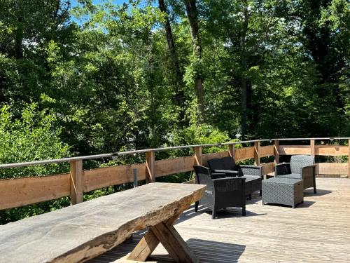 a wooden bench and chairs on a wooden deck at Domaine des Constellations - Tiny Houses & Bains Nordiques in Orbey