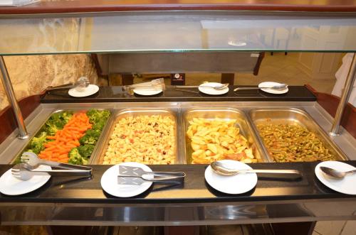 a buffet with many trays of food in a restaurant at Indigo Mare in Plataniás
