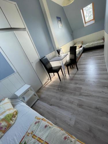 a room with two beds and a table and chairs at Dom Gościnny Tomasz Mielenko in Mielenko