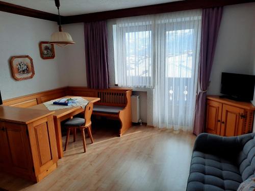 a living room with a wooden table and a desk at Haus Renate in Lermoos
