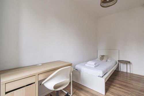 une chambre avec un lit, un bureau et une chaise dans l'établissement Pentagone 23 Stade de Reims, à Reims