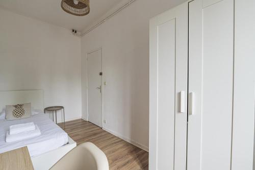 - une chambre blanche avec un lit et une armoire blanche dans l'établissement Pentagone 23 Stade de Reims, à Reims