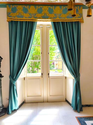 a room with two windows with blue curtains at La Casa Di Agartha in Bolsena