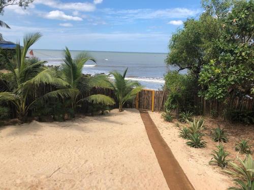 a pathway to the beach with the ocean in the background at SaffronStays Stella Maris - Luxury Beach Front Villa Near Redi Beach in Querim