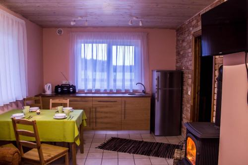 una cucina con tavolo e frigorifero di Holiday Home Četri Vēji a Turkalne