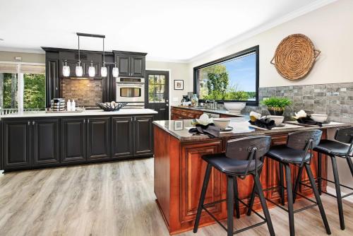 a kitchen with black cabinets and a island with bar stools at Ringneck Retreat in Mooresville