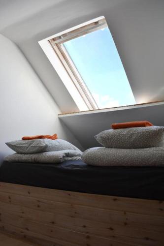 a group of towels sitting on a bed under a window at Jurgis Guest house in Kaunas
