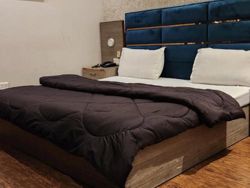 a bedroom with two beds with a blue headboard at Hotel City Premier - Golf Course Road ,Gurgaon in Gurgaon