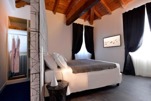 a bedroom with a white bed and black curtains at Phi Hotel Bologna in Bologna
