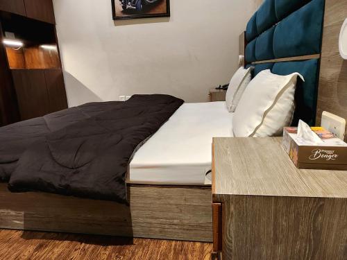 a bed in a small room with a wooden table at Hotel City Premier - Golf Course Road ,Gurgaon in Gurgaon