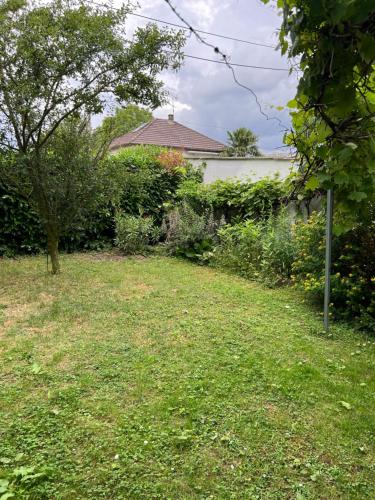 a yard with a field of grass and a building at Maison Indépendante CHELLES , Paris Disney Proche JO 2024 Vaires sur Marne est a 10 minutes de Chelles des épreuves Olympique de canoé kayac 2 chambres in Chelles