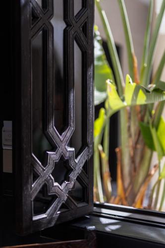 a wooden mirror sitting on a table with a plant at Alrashid Marrakech Boutique Hotel & SPA in Marrakech