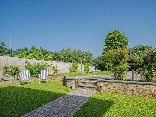 a garden with two chairs and a bench at Holiday Home Villa Giuliana by Interhome in Querceta
