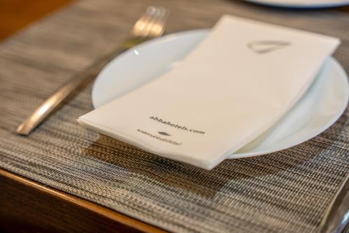 a white plate with a napkin on a table at Abba Rambla Hotel in Barcelona