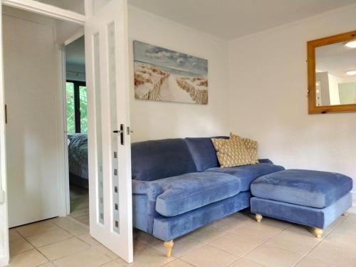 a living room with a blue couch and a mirror at Rebels Retreat - 2-Bed Chalet nr St Ives & Hayle in St Ives