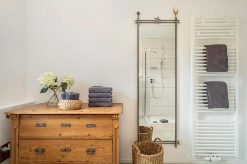 a bathroom with a wooden dresser and a mirror at Time Out - Appartement Bodensee in Friedrichshafen