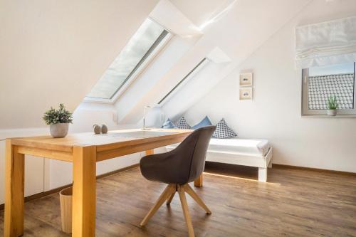 a desk with a chair in a room with a bed at Time Out - Appartement Bodensee in Friedrichshafen