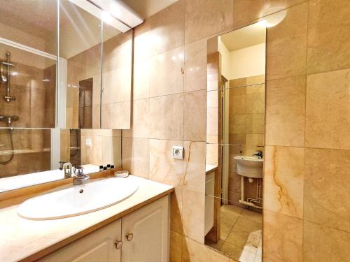 une salle de bain avec un lavabo et une douche en verre dans l'établissement Passage Doisy - Paris 17, à Paris