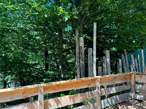 a wooden fence with trees in the background at Domaine des Constellations - Tiny Houses & Bains Nordiques in Orbey