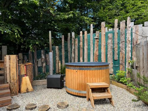 a barrel and a stool and a wooden fence at Domaine des Constellations - Tiny Houses & Bains Nordiques in Orbey