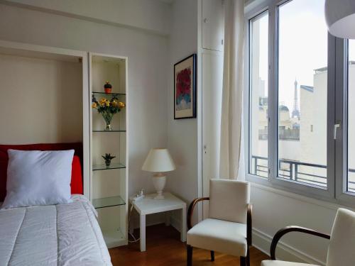 une chambre avec un lit, une chaise et une fenêtre dans l'établissement Avenue Franklin Roosevelt - Paris 8, à Paris