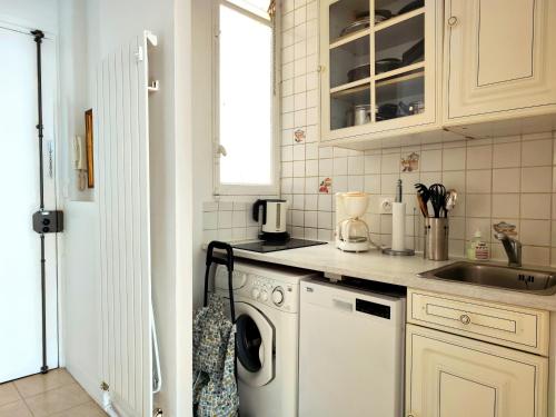 une cuisine avec une machine à laver et un évier dans l'établissement Avenue Franklin Roosevelt - Paris 8, à Paris