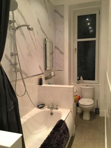 a bathroom with a tub and a toilet at Beautiful 2 double bedrooms, 2 baths apartment in Port Glasgow