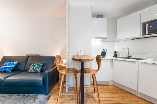 un salon avec un canapé bleu et une table dans l'établissement Superbes Studios - Place des Quinconces, à Bordeaux