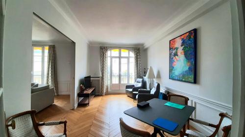 un salon avec une table et un canapé dans l'établissement Avenue Saint Honore d'Eylau - Paris 16, à Paris