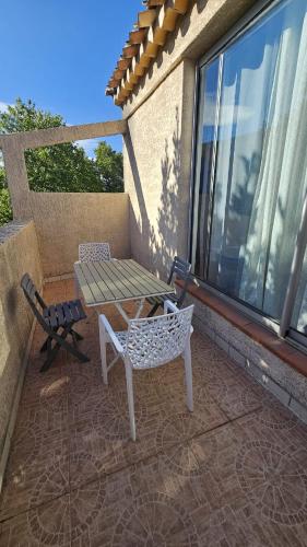 un patio avec une table et des chaises sur un balcon dans l'établissement Studio 2D, à Avignon