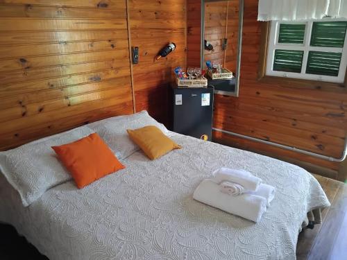 a bedroom with a bed with orange and white towels on it at Pousada Florada na Serra - Apto 1 in Campos do Jordão