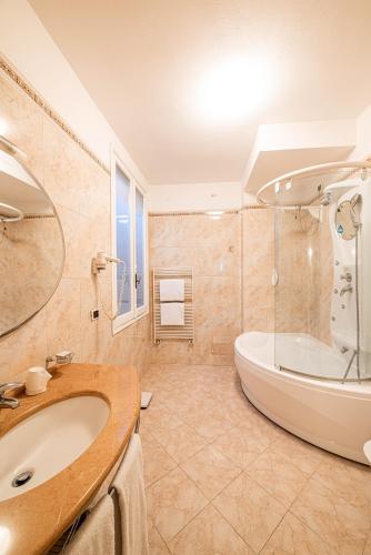 a bathroom with a large tub and a sink at Phi Hotel Canalgrande in Modena