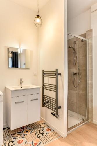 une salle de bain avec une douche, un lavabo et un miroir dans l'établissement Le Logis de Joseph au pied de la Cité Médiévale, à Carcassonne